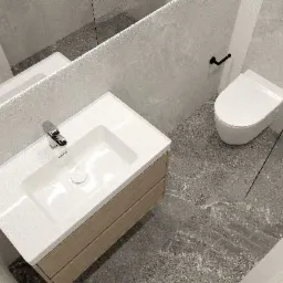 Nowoczesna łazienka w Dobrej z umywalką nablatową na drewnianej szafce, toaletą w zabudowie i szarą marmurową posadzką, widoczna z góry.