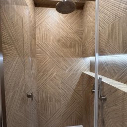 Global Labs sp. z o.o. - Kabina prysznicowa z deszczownicą i geometrycznymi płytkami imitującymi drewno. Nowoczesny design z podświetleniem LED. Widok z dołu na górę.