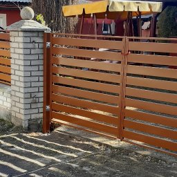 PPHU ROB-MAR Robert Marek - Nowoczesne ogrodzenie posesji z poziomych, brązowych paneli metalowych, osadzone na niskim murku z cegły. Brama dwuskrzydłowa zamykana na zasuwkę.