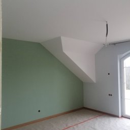 Andrzej Sarkowicz Remonty i wykończenia - Pokój na poddaszu po malowaniu ścian na zielono i szaro, z widocznym otworem na oświetlenie w suficie i zabezpieczeniem podłogi folią malarską.