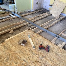 Usunięcie starej podłogi. Położenie nowej podłogi z OSB ze względu na różne poziomy w mieszkaniu - stara kamienica.