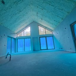 PC PUR Paweł Czerwiak - Poddasze domu jednorodzinnego po ociepleniu pianką PUR w Piasecznie. Widoczne okna dachowe i ściany przygotowane do dalszych prac wykończeniowych.