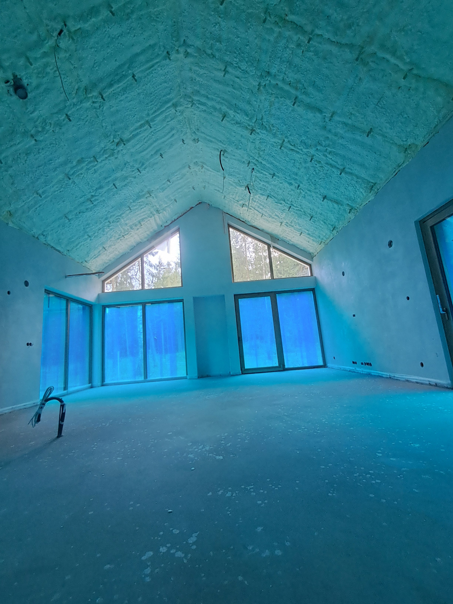 Poddasze domu jednorodzinnego po ociepleniu pianką PUR w Piasecznie. Widoczne okna dachowe i ściany przygotowane do dalszych prac wykończeniowych.