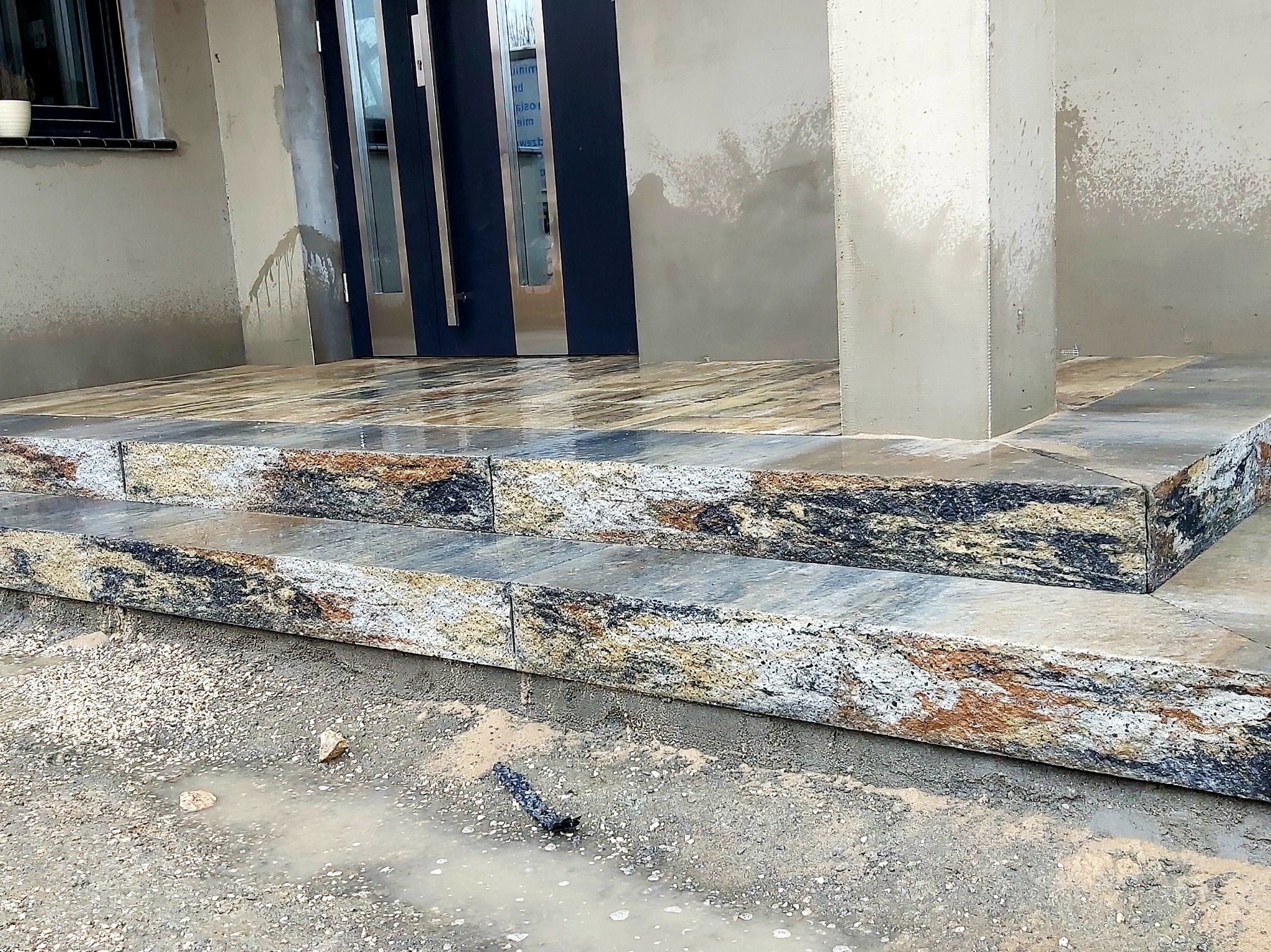 Wejście do domu z gotowych bloków schodowych wypełnione płytką większego formatu