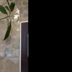 Beżowa, kwadratowa płytka ścienna z wypukłym wzorem, obok fragmentu ciemnobrązowych drzwi z białą ościeżnicą, z lewej strony doniczka z zieloną rośliną.