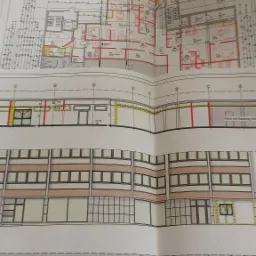 Architektoniczny plan wielokondygnacyjnego budynku mieszkalnego z zaznaczonym układem pomieszczeń i elewacją, widoczne wymiary i oznaczenia techniczne.