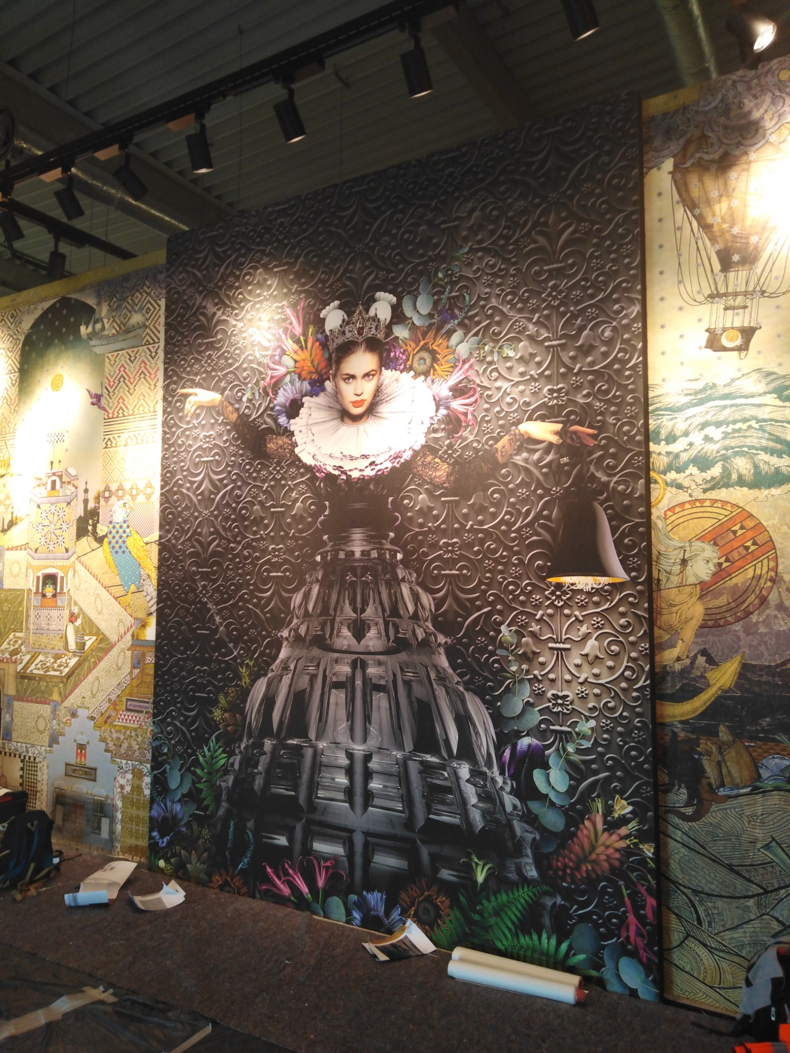 Wnętrze z trzema panelami dekoracyjnymi: pierwszy z motywem bajkowej architektury, drugi z portretem kobiety w królewskiej sukni na tle ornamentów, trzeci z motywem balonu i morskich krajobrazów,...