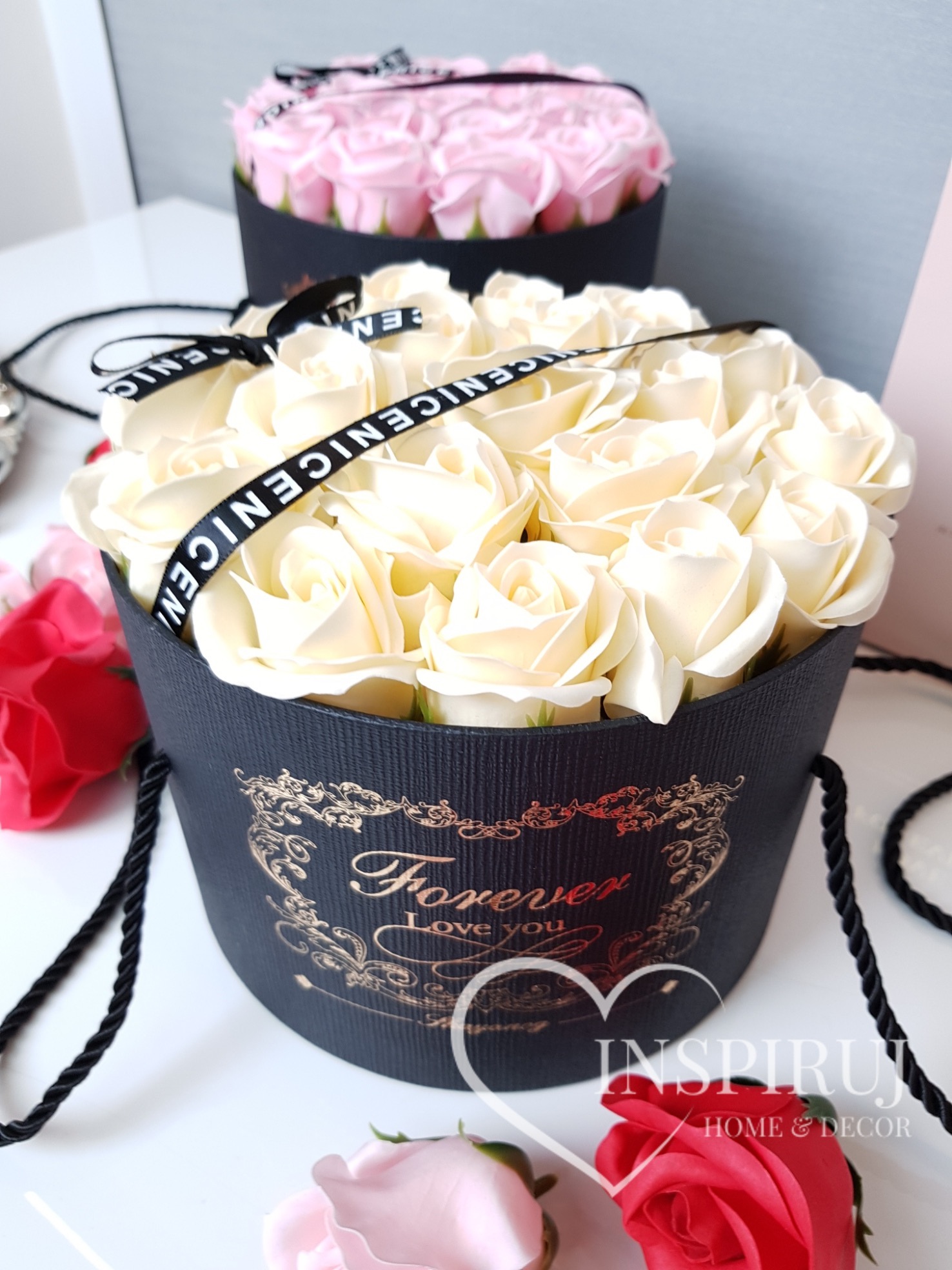 Kremowe róże z mydła w czarnym, okrągłym pudełku z napisem 'Forever I love you' i czarną wstążką z napisem 'NICE NICE NICE', w tle różowe róże w podobnym pudełku.