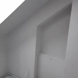 Pomalowane na szaro poddasze ze skosem i wnęką w Sochaczewie, widoczny fragment podłogi z listwami przypodłogowymi.