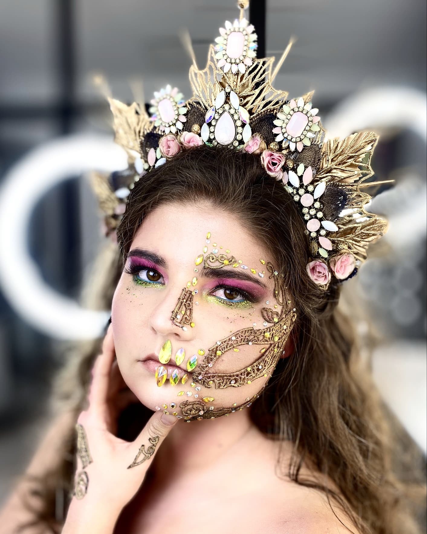 Portret kobiety z artystycznym, asymetrycznym zdobieniem twarzy w stylu meksykańskiego święta zmarłych; połowa twarzy z intensywnym makijażem oczu w odcieniach różu i zieleni, druga połowa...