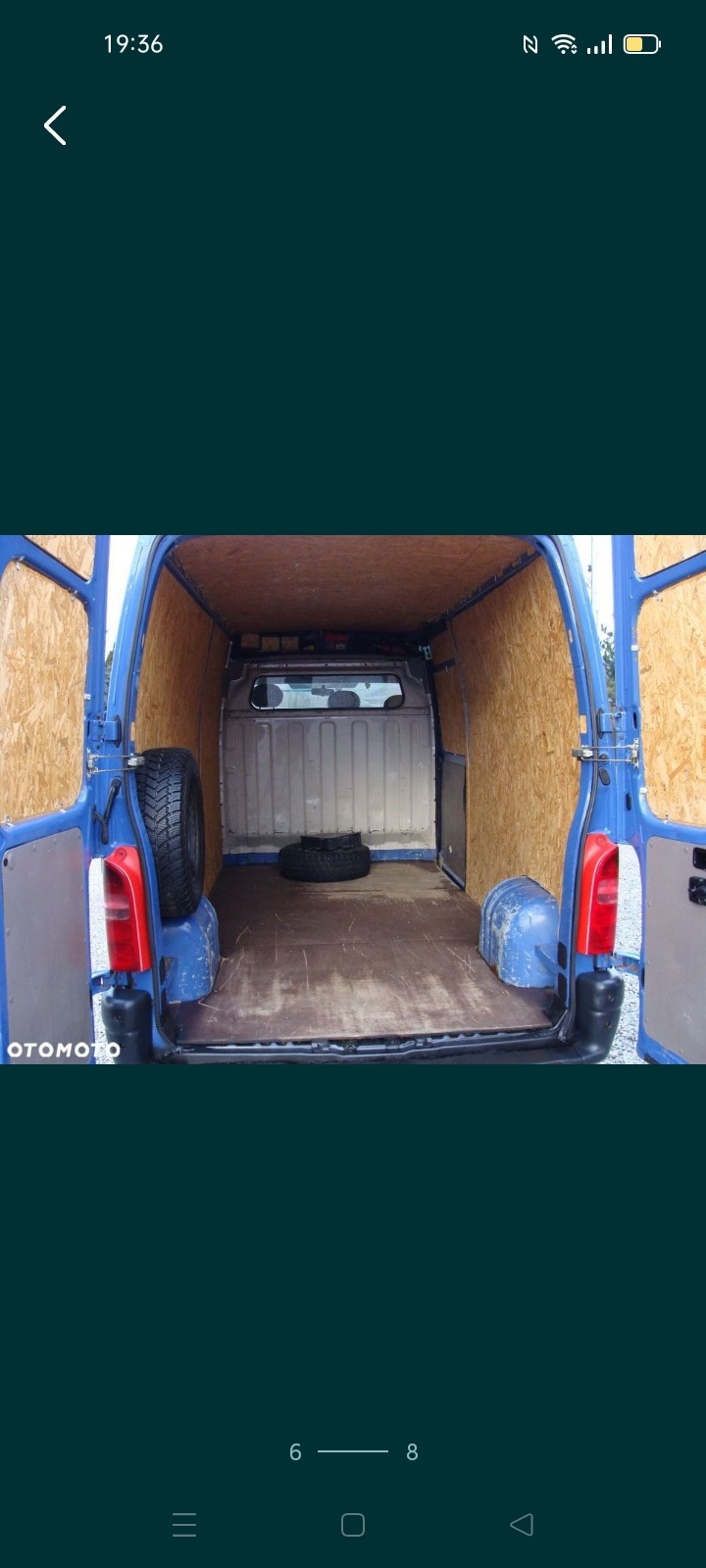 Wnętrze niebieskiego busa wyłożone płytami OSB, widoczne dwa koła zapasowe