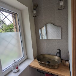 Lech-Bud - Aranżacja małej łazienki z umywalką w stylu retro, armaturą w kolorze starego brązu, lustrem w ozdobnej ramie i lampami ściennymi w stylu industrialnym.