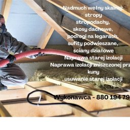 Usługi remontowo budowlane Tomasz Muła - Pracownik w kombinezonie ochronnym i masce aplikuje wełnę mineralną za pomocą specjalistycznego urządzenia do ocieplania poddasza, widoczne drewniane elementy konstrukcji dachu.