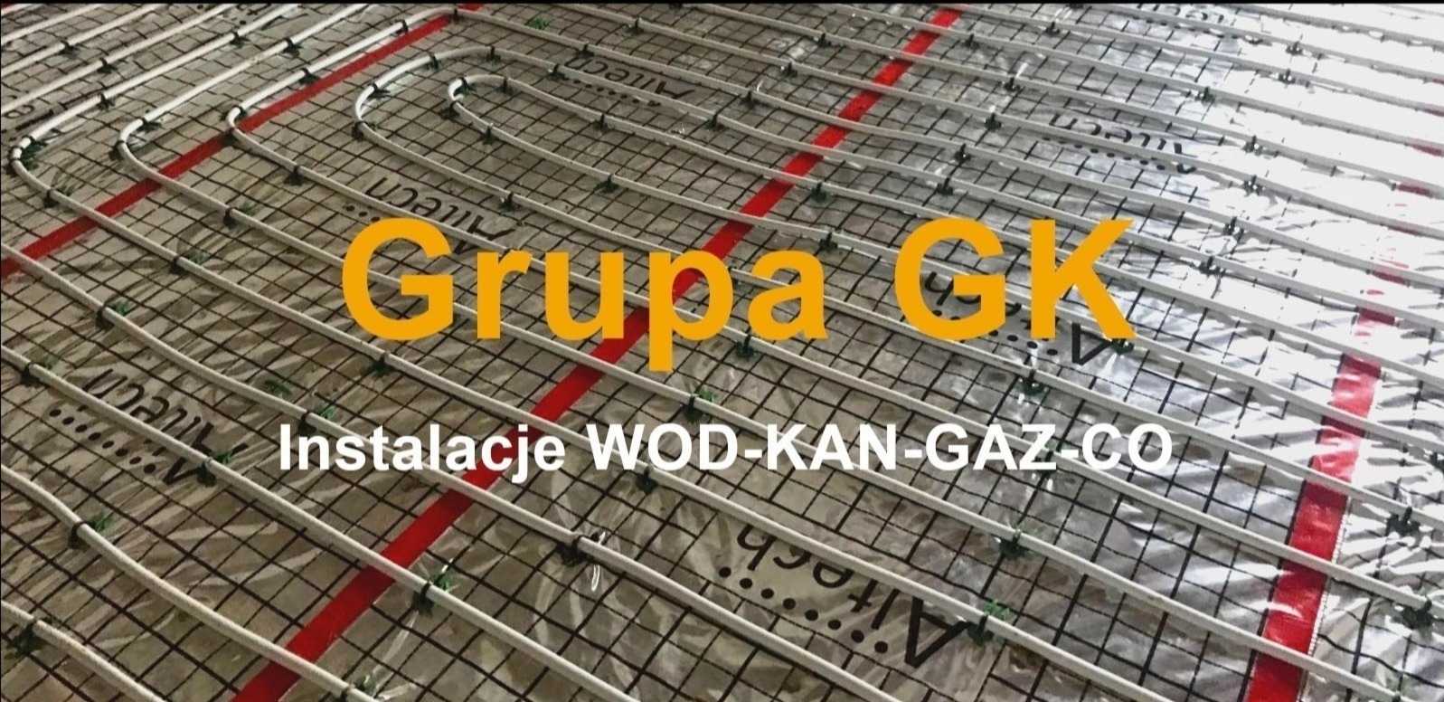 Białe rury ogrzewania podłogowego ułożone na czarnej siatce z czerwonymi pasami, widoczne napisy Altech i logo firmy Grupa GK.