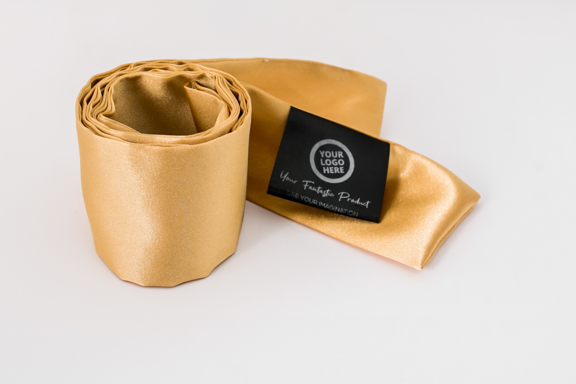 Zrolowany złoty materiał satynowy z czarną etykietą z napisem 'Your Logo Here' i 'Your Fantastic Product', na białym tle.