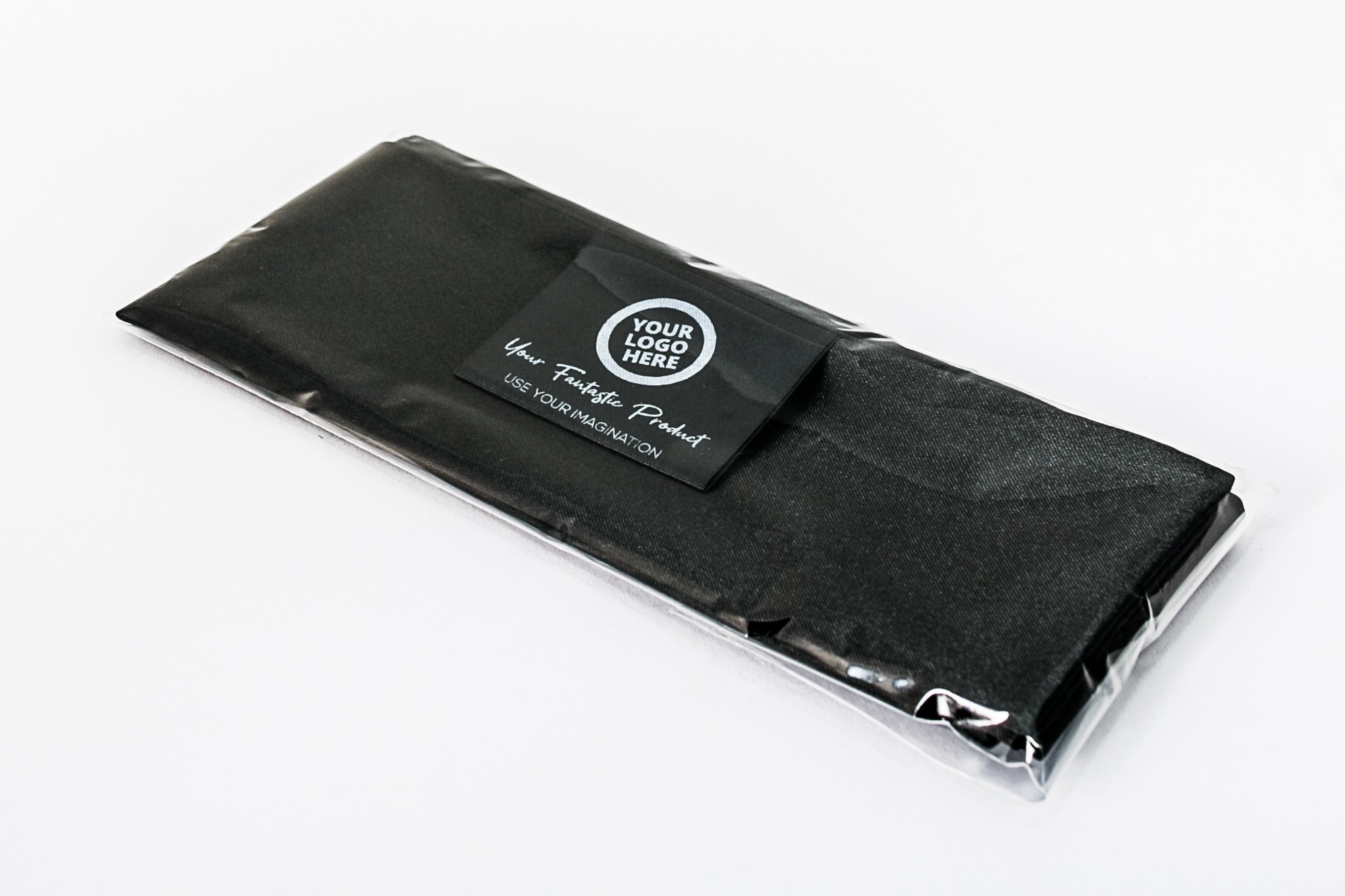 Czarny materiał tekstylny zapakowany w folię z etykietą 'Your Logo Here' od firmy z Piły, gotowy do nadruku.