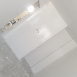 DAST - Świeżo pomalowany na biało sufit z widocznym otworem instalacyjnym i fragmentem ściany z plamami po gładzi.