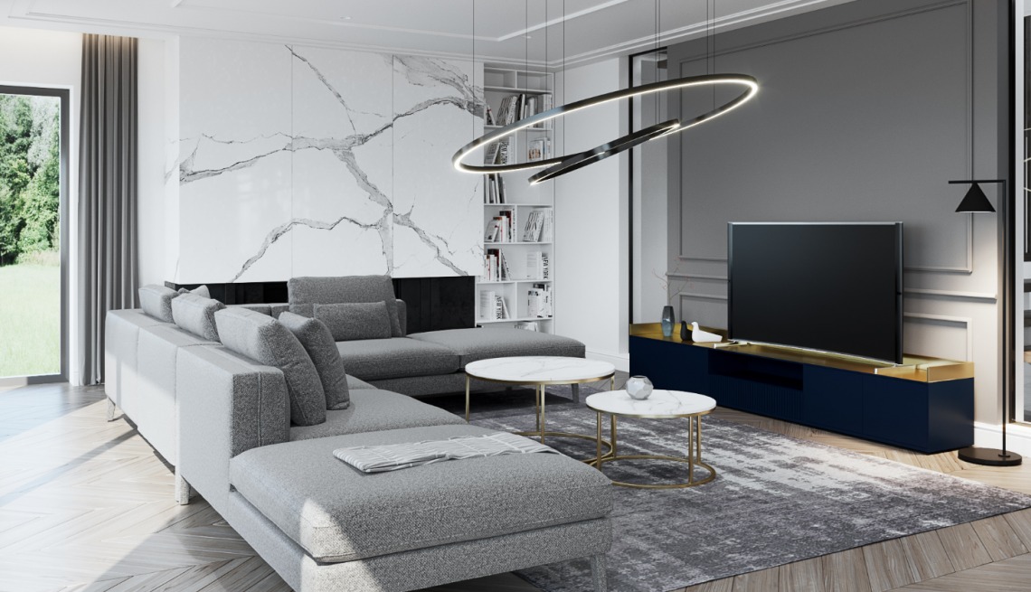 Nowoczesny salon z szarym narożnikiem, marmurową ścianą akcentującą i designerską lampą pierścieniową nad marmurowymi stolikami kawowymi.