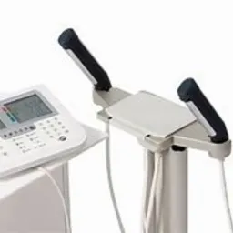 Profesjonalny analizator składu ciała z widocznym panelem sterowania i uchwytami do pomiaru, ustawiony na białym tle.