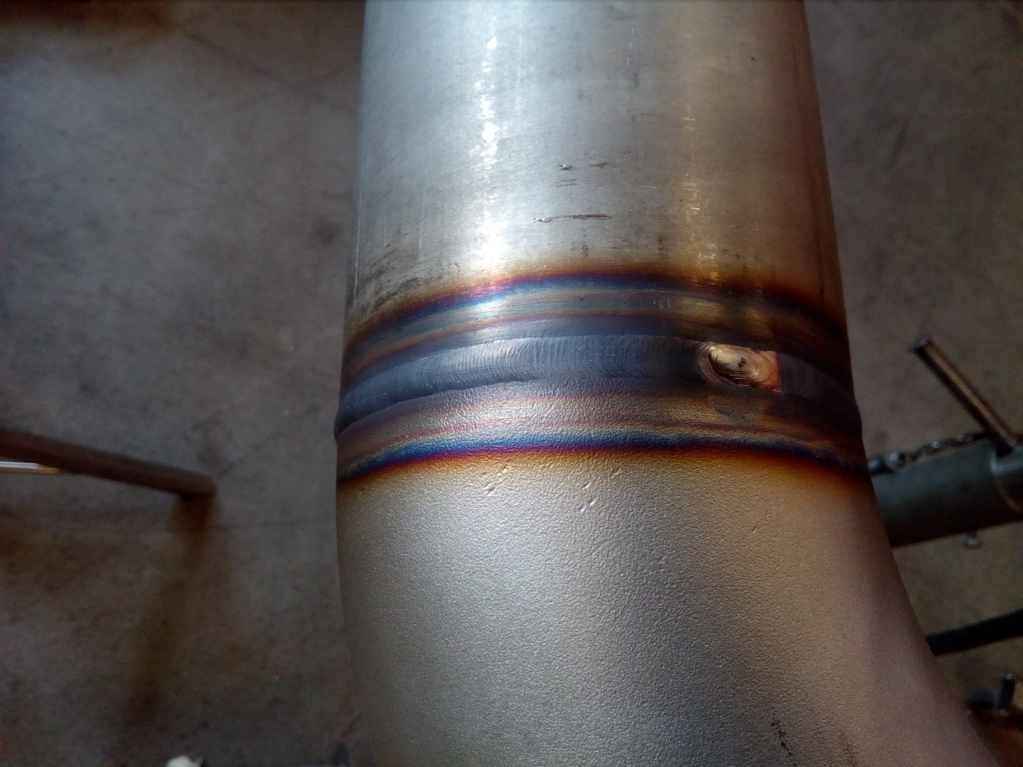 Spoina na rurociągu ze stali nierdzewnej, widoczne przebarwienia termiczne po procesie spawania.