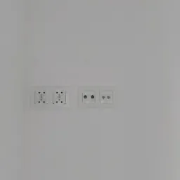 Dwa podwójne gniazdka elektryczne i gniazdo antenowe oraz sieciowe zamontowane na białej ścianie.