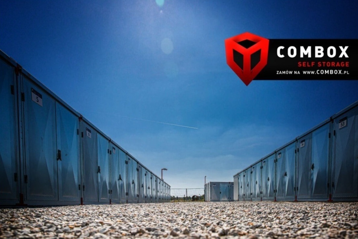 Rząd srebrnych kontenerów do samoobsługowego składowania pod błękitnym niebem, widok z poziomu gruntu, logo firmy Combobox u góry.