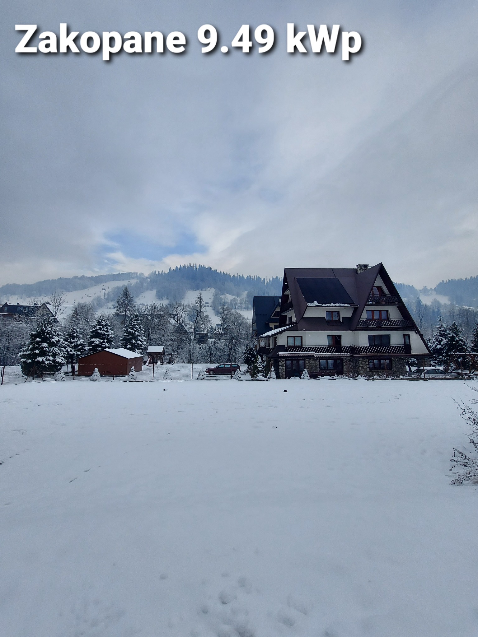 Dom w stylu góralskim w zimowej scenerii z panelami słonecznymi na dachu, widoczny napis 'Zakopane 9.49 kWp'.