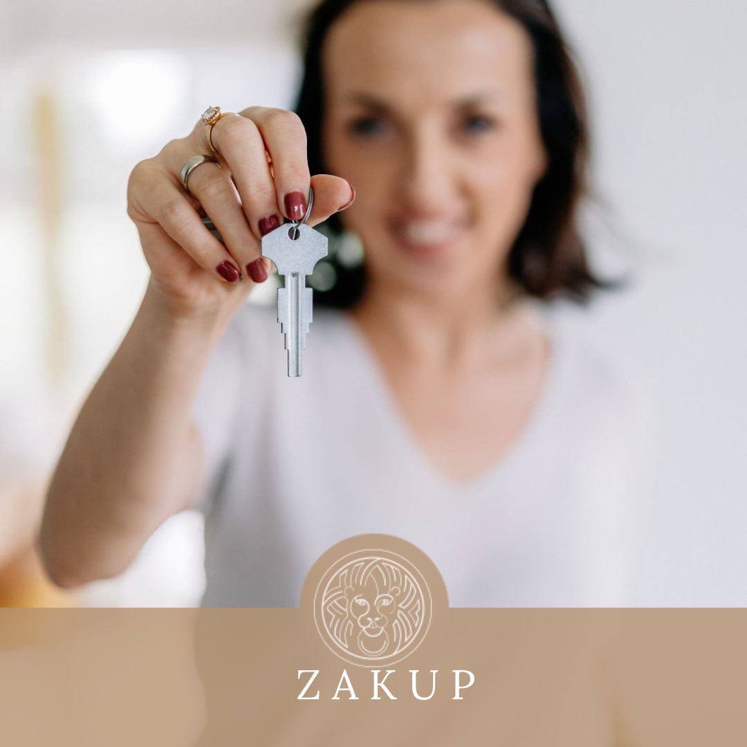 Kobieta z rozmazanym tłem trzyma klucz do mieszkania z pomalowanymi na bordowo paznokciami i złotymi pierścionkami na palcach, widoczne logo firmy ZAKUP.