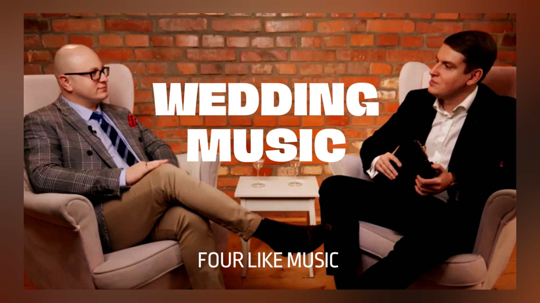 Dwóch mężczyzn w eleganckich strojach siedzi w fotelach na tle ceglanej ściany, z napisem 'WEDDING MUSIC FOUR LIKE MUSIC' nałożonym na obraz.