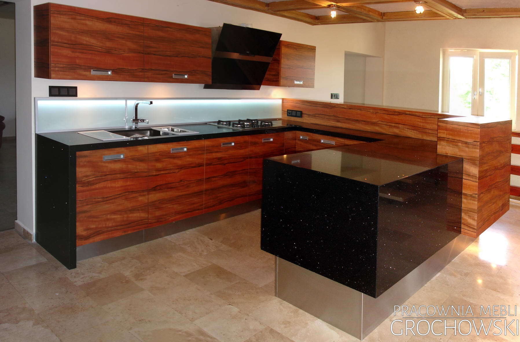 Nowoczesna kuchnia na wymiar z fornirem w odcieniach brązu, czarnym blatem z połyskiem i wyspą kuchenną, oświetleniem LED pod szafkami i drewnianym sufitem.