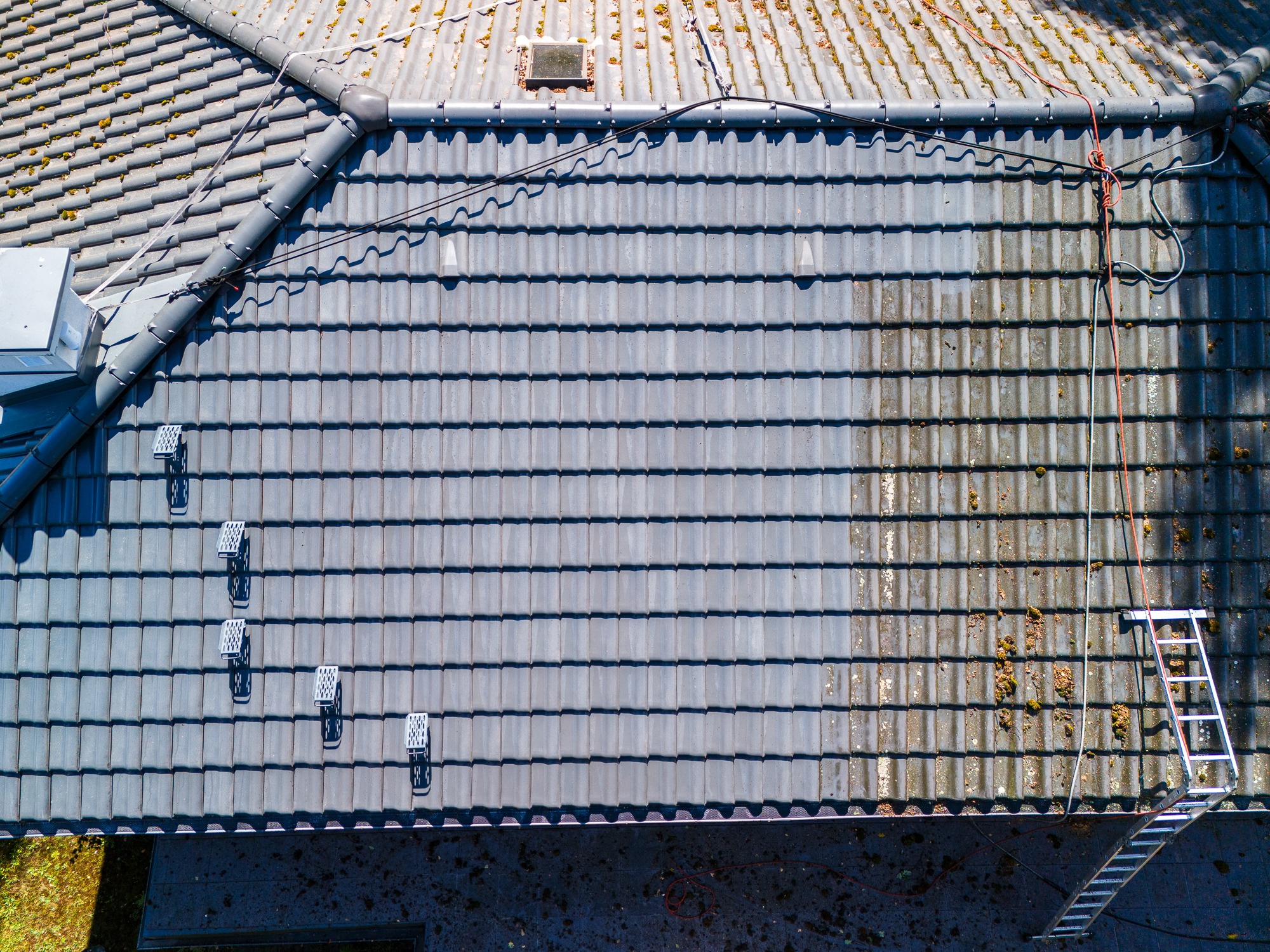 Dach domu jednorodzinnego w trakcie mycia. Efekt widać gołym okiem.