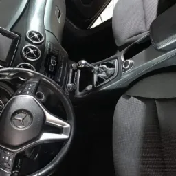 Wnętrze samochodu marki Mercedes, widok z góry na kierownicę, deskę rozdzielczą, fotele i podłogę, po czyszczeniu.