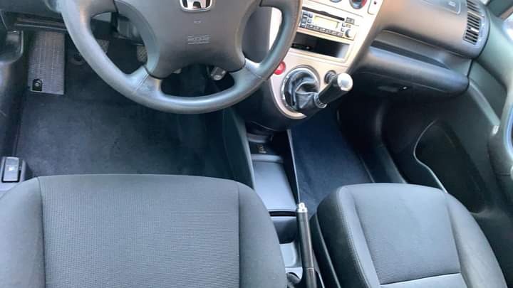 Wnętrze samochodu Honda Civic, widok na kierownicę, deskę rozdzielczą i przednie fotele z ciemną tapicerką po czyszczeniu.
