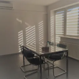 Kwadratowy stół z czterema krzesłami w pustym jasnym pomieszczeniu, światło słoneczne w paski wpadające przez żaluzje okienne.