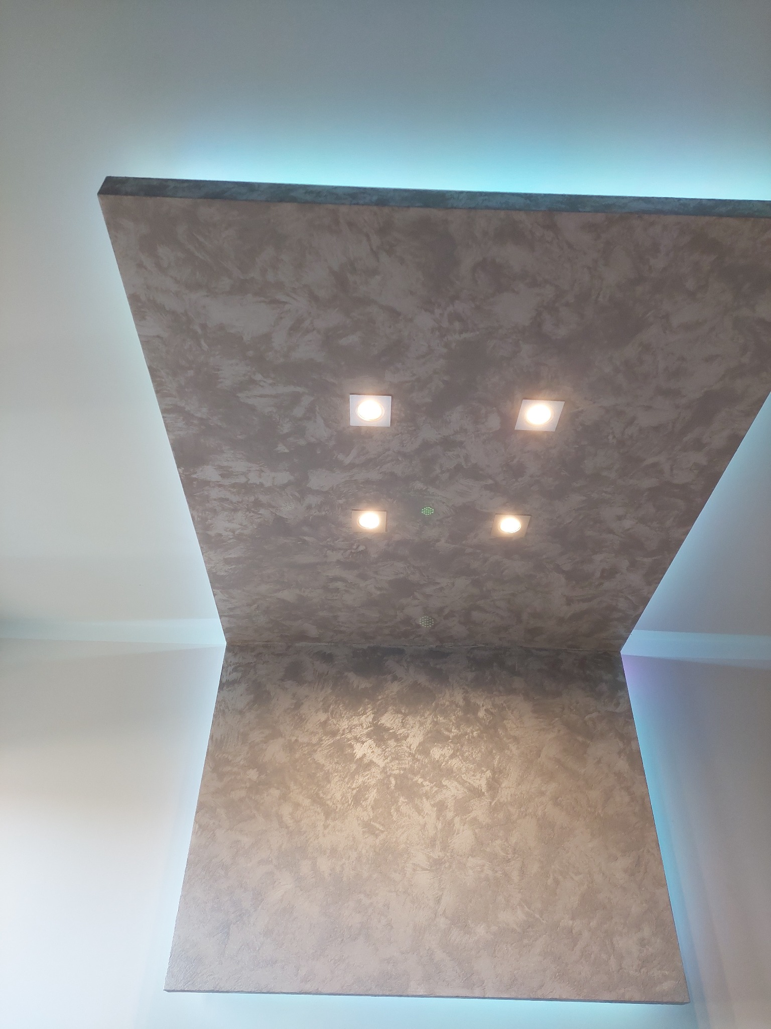 Wykończony fragment sufitu z dekoracyjną strukturą i oświetleniem LED, z czterema wbudowanymi punktami świetlnymi.