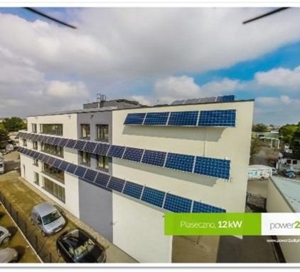 Budynek biurowy w Piasecznie z zamontowanymi panelami fotowoltaicznymi o mocy 12kW, widok z góry, częściowo pochmurne niebo.