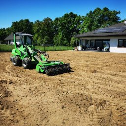 Xenimar - Przygotowanie terenu pod trawnik z wykorzystaniem glebogryzarki separacyjnej Avant 528, widoczne ślady opon na wyrównanej ziemi, w tle dom z panelami słonecznymi i ogrodzenie.