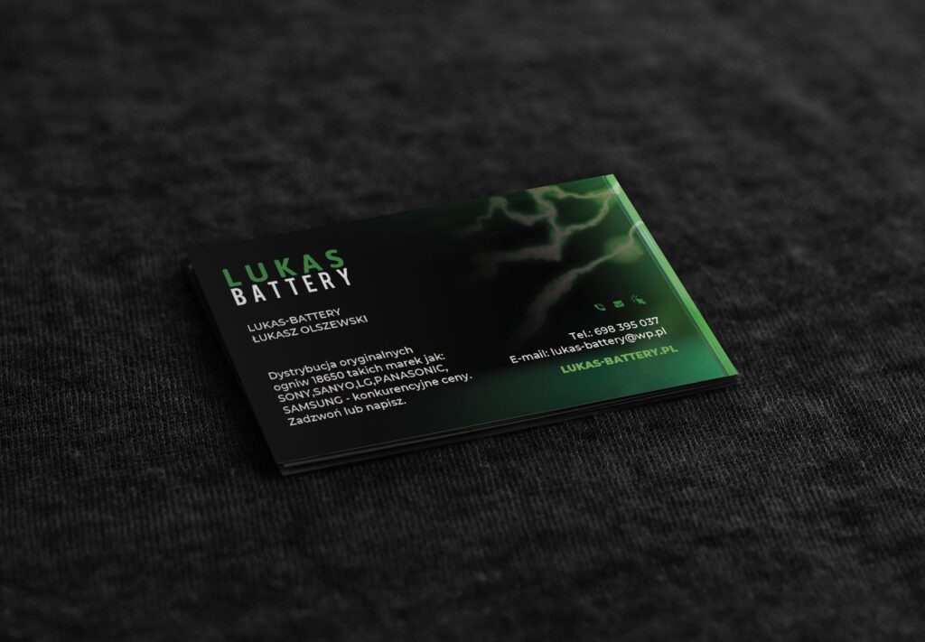 Czarno-zielona wizytówka firmy Lukas Battery leży na ciemnoszarym, teksturowanym tle. Wizytówka zawiera logo, dane kontaktowe i informacje o dystrybucji baterii.
