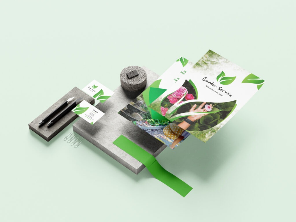 Mockup materiałów reklamowych dla firmy ogrodniczej: ulotka, wizytówki, ołówki i spinacze biurowe na geometrycznych blokach w pastelowej tonacji.