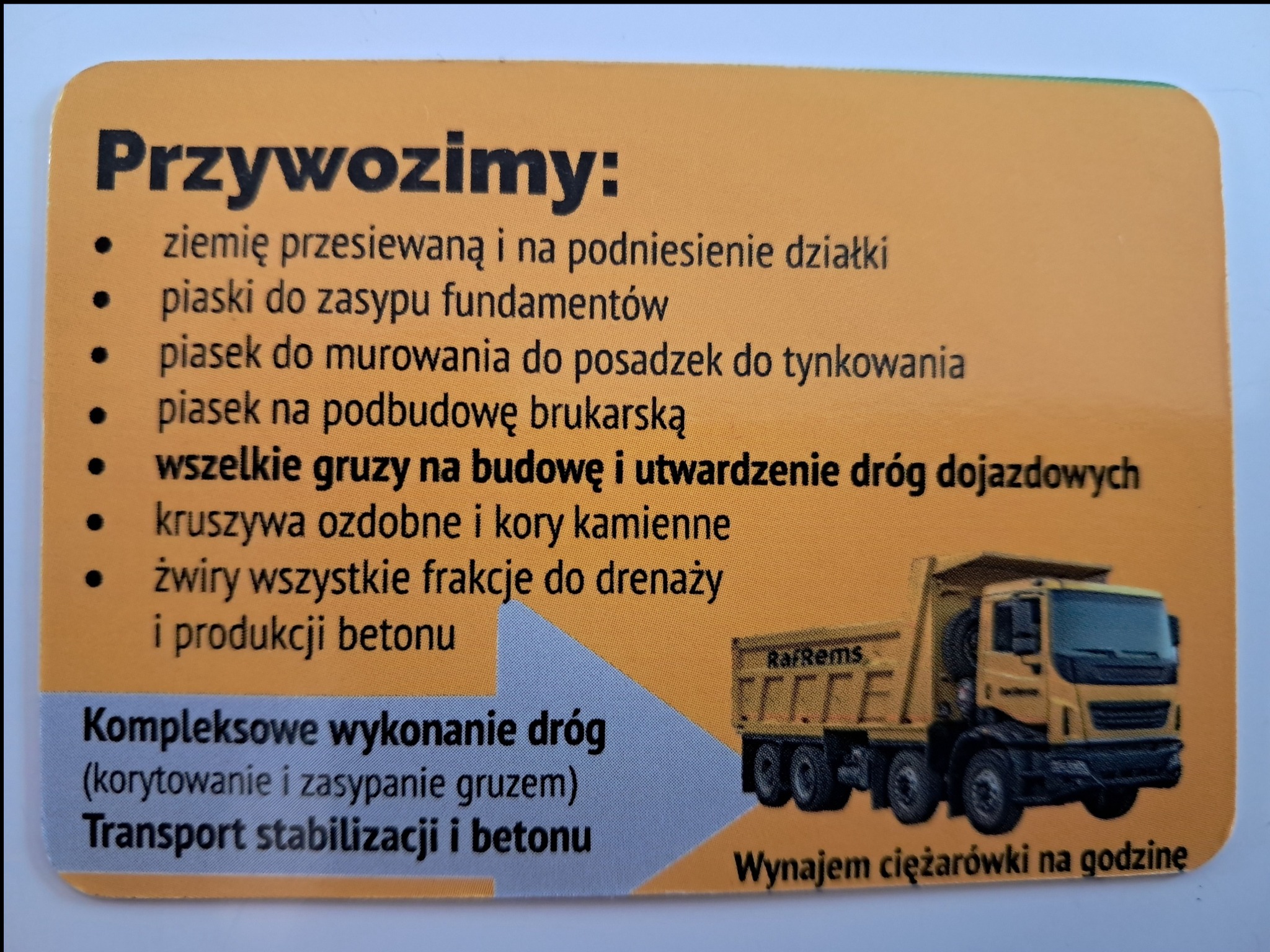 Żółta wizytówka firmy budowlanej z ofertą: ziemia przesiewana, piaski do fundamentów, piasek do murowania, gruz, kruszywa, żwiry, kompleksowe wykonanie dróg, transport stabilizacji i betonu...