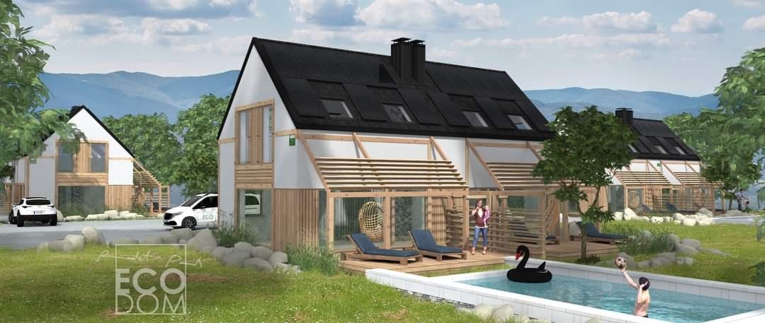 Wizualizacja osiedla domów z białymi elewacjami i drewnianymi elementami, czarnym dachem z panelami solarnymi, basenem z pływającym czarnym łabędziem i bawiącymi się dziećmi, tle górski krajobraz.
