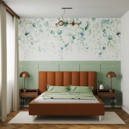 Tomasz Kalinowski - Sypialnia z łóżkiem w odcieniach brązu i zieleni, tapeta w liście eukaliptusa, drewniana podłoga w jodełkę, lampki nocne z miedzianymi abażurami.