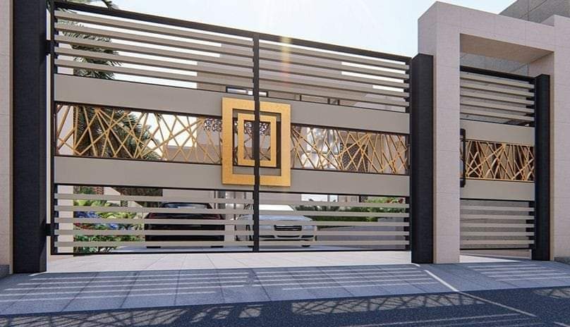 Nowoczesna brama wjazdowa z poziomymi panelami, dekoracyjnymi wstawkami o geometrycznym wzorze i złotym, kwadratowym ornamentem centralnym, widok z zewnątrz posesji.