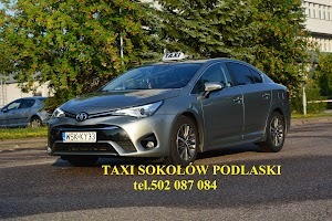 Szary samochód osobowy z napisem TAXI na dachu, zaparkowany w Sokołowie Podlaskim, widoczny numer rejestracyjny WSK KY33 i kontaktowy numer telefonu na dole kadru.