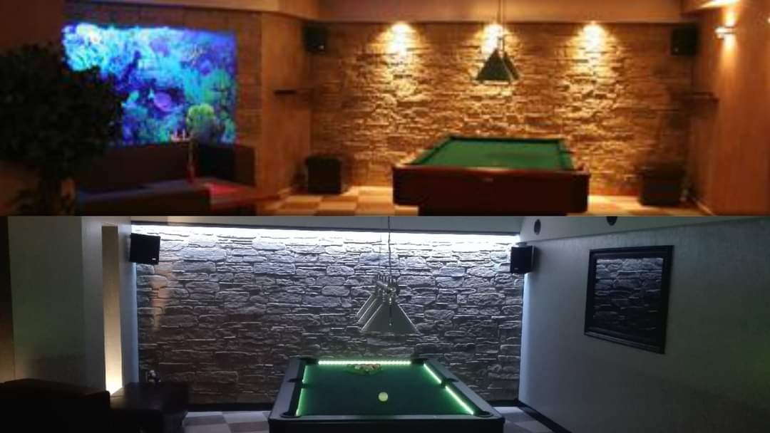 Dwa ujęcia pokoju bilardowego z dekoracyjną ścianą z kamienia: na górze ciepłe oświetlenie i akwarium, na dole chłodne światło i obraz w ramie.