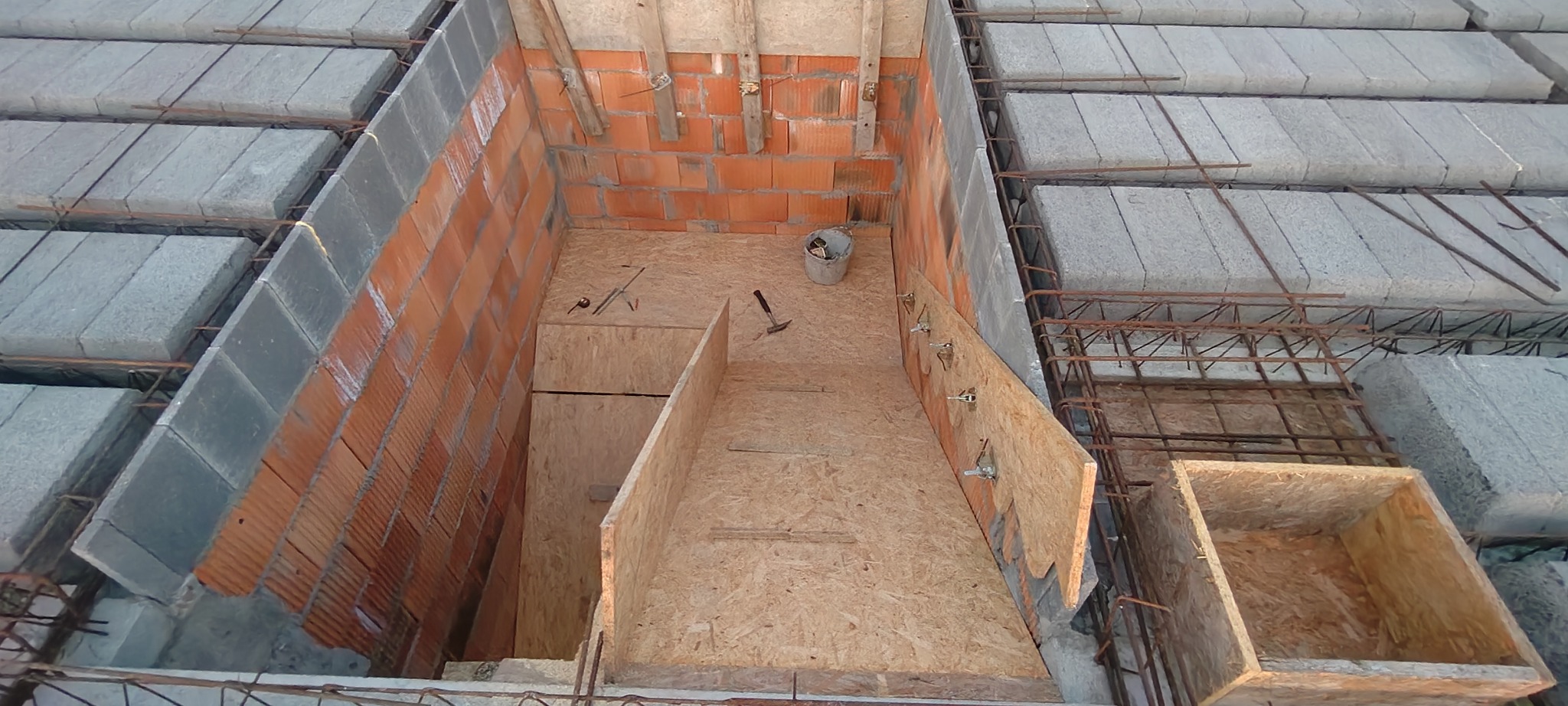 Wnętrze budowy: murowane ściany z pustaków, szalunek z płyty OSB, zbrojenie stropu. Widok z góry na przygotowania do wylewania stropu.