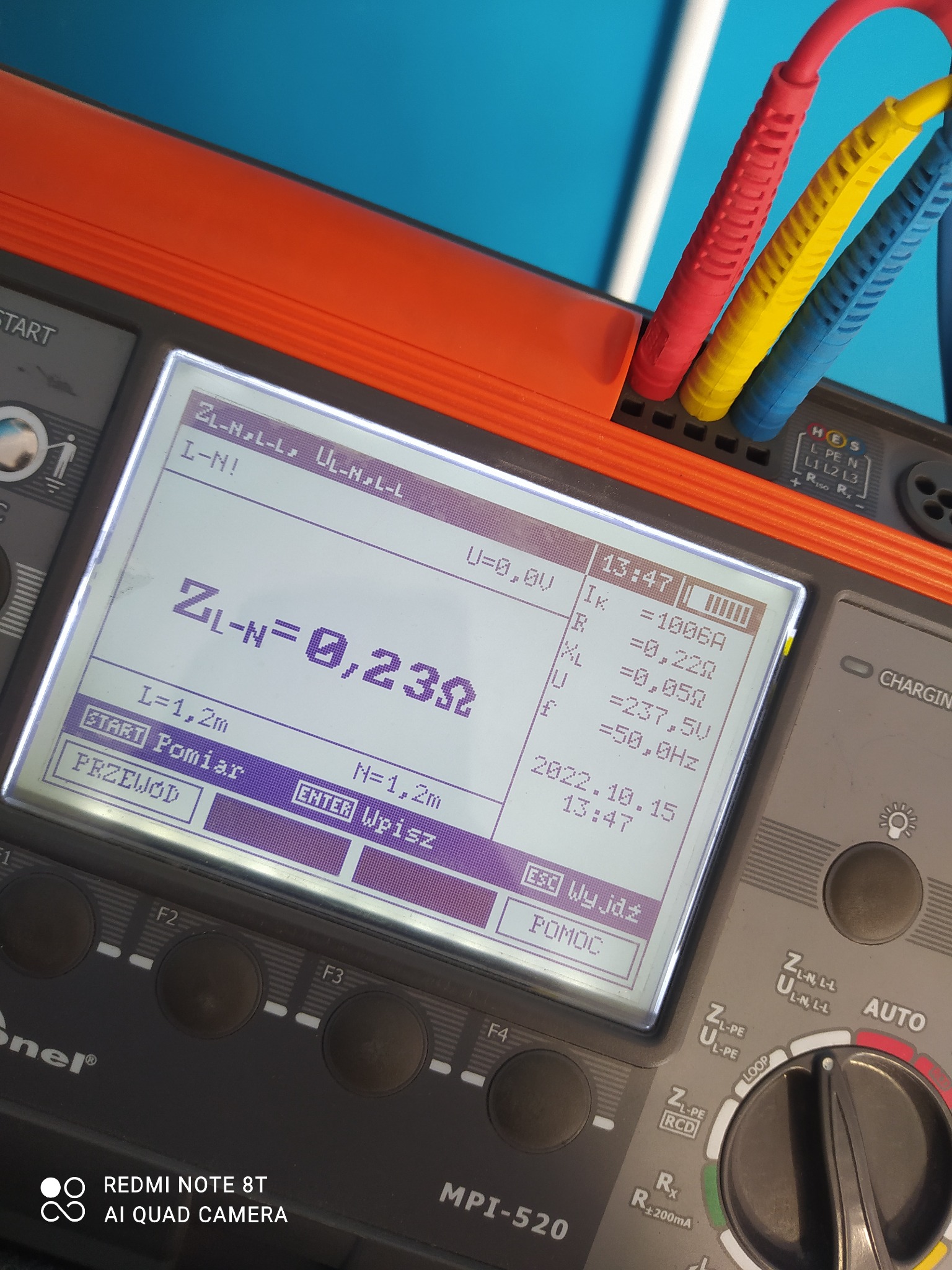 Miernik elektryczny MPI-520 z widocznym ekranem wyświetlającym wynik pomiaru impedancji pętli zwarcia ZL-N=0,23Ω, trzy kolorowe przewody pomiarowe w górnej części urządzenia.