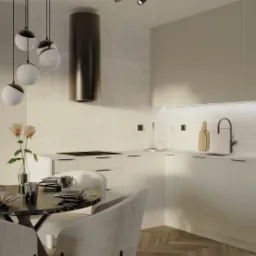 Nowoczesna kuchnia z okrągłym stołem z czarnego marmuru i beżowymi krzesłami, nad stołem wiszą kuliste lampy, a w tle widoczny sprzęt AGD w zabudowie.