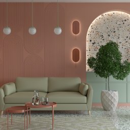 ProReal Studio Justyna Kępa - Stylowy salon z pastelową kolorystyką: łososiowe ściany z geometrycznym wzorem, pistacjowa sofa, okrągłe lampy i fotel w odcieniu brzoskwini. Całość dopełnia marmurowa podłoga.