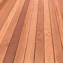 Ukończony taras z desek kompozytowych w odcieniach brązu, ułożonych równolegle. Widoczna faktura drewna i regularne odstępy między deskami.